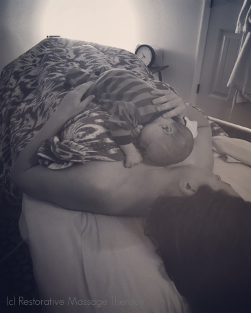 Mother and newborn resting during postpartum massage.